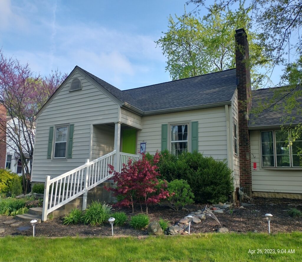 tan siding with green shutters