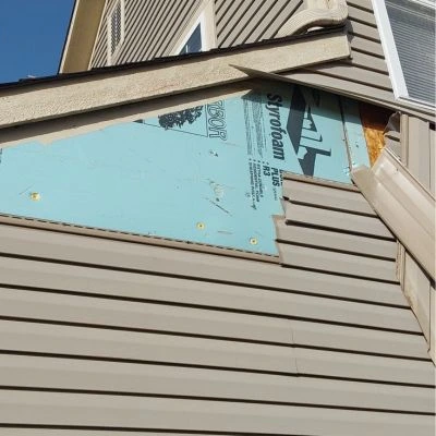Grey home in need of siding repair 