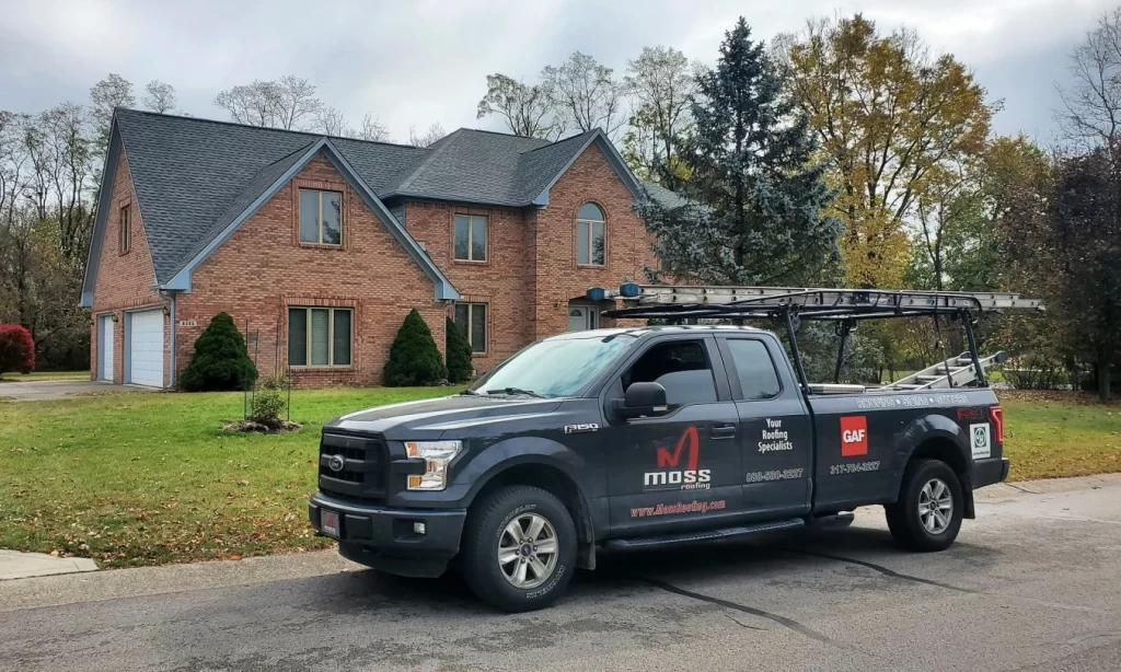 Brick home with Moss Roofing Truck Out Front