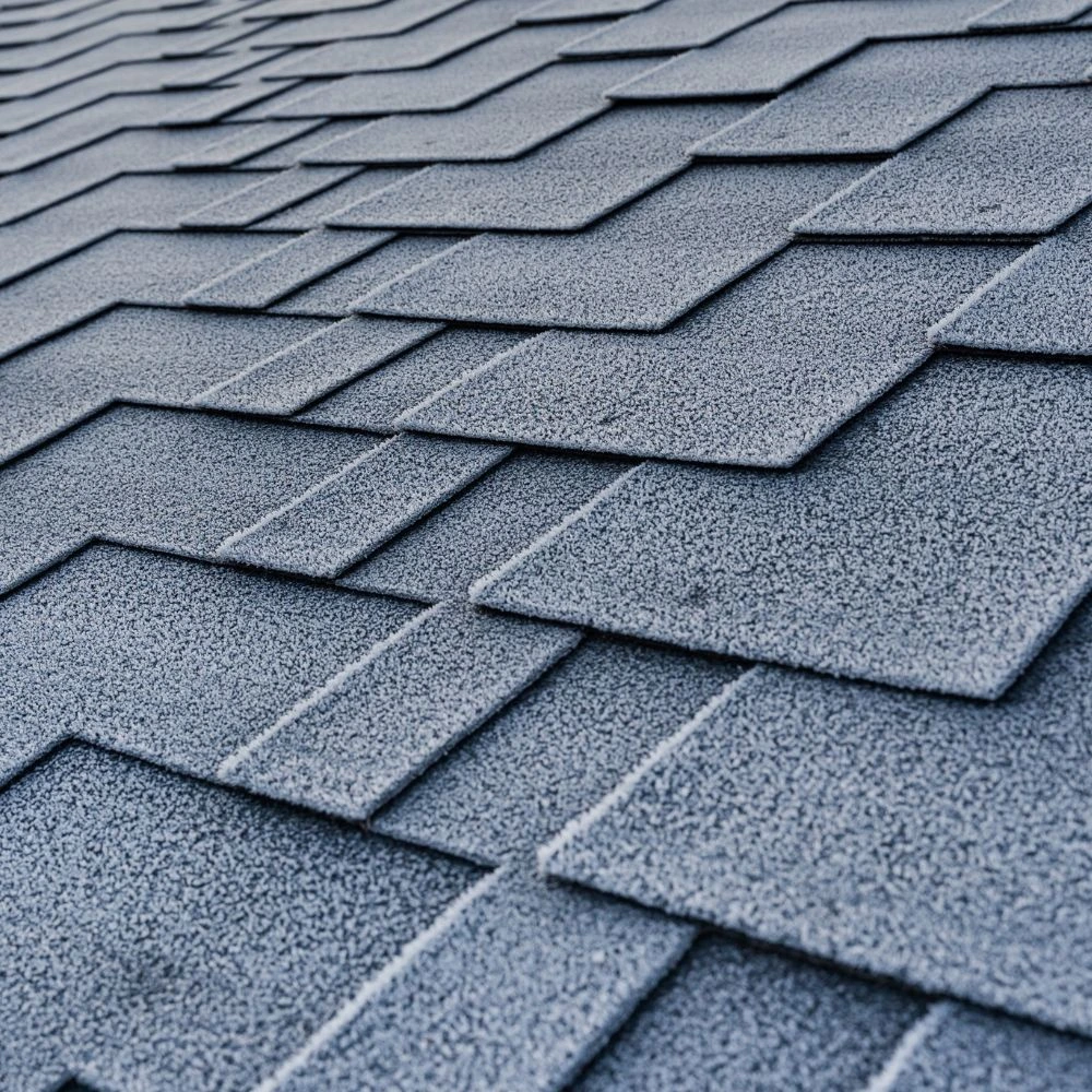 Close-up detail of gray architectural asphalt shingles showing texture and overlapping installation pattern