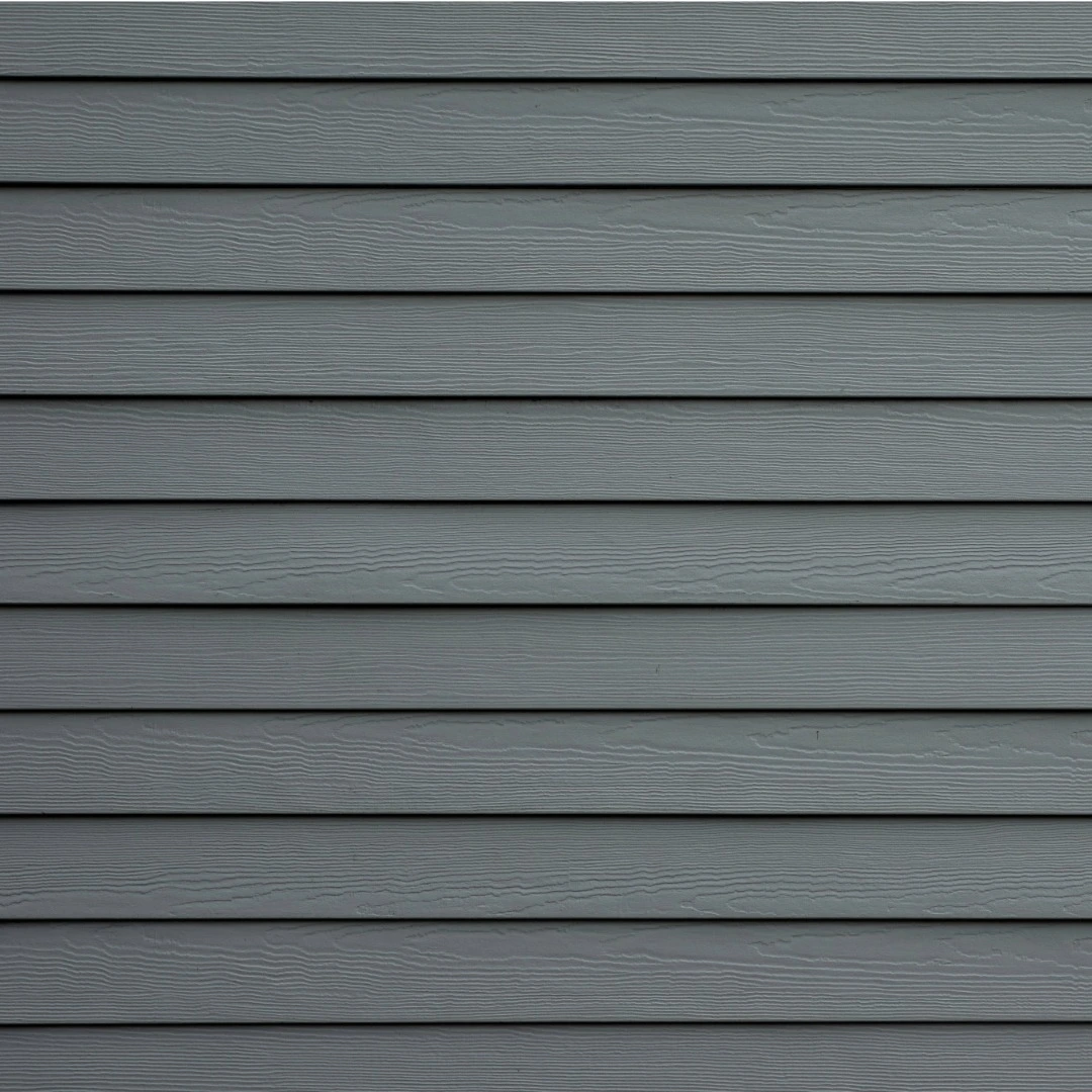 Close-up view of gray fiber cement siding panels showing wood-grain texture.