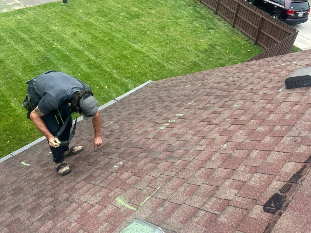 Moss Roofer marking hail damage on roof