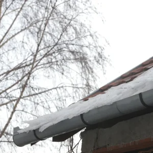 Roof with snow and ice build up in the gutter.