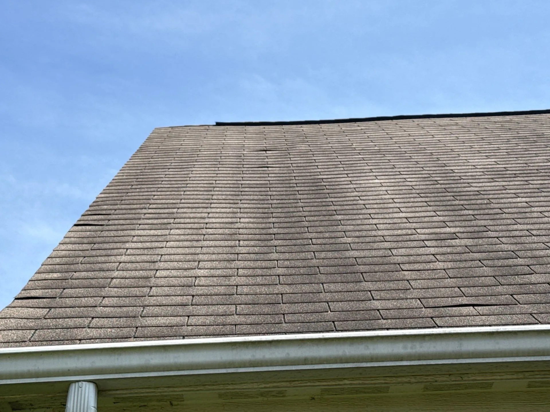 Before: damaged/aged roof shingles. Lifting shingles visible from ground